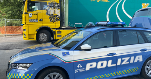Italienisches Polizeitauto mit der Aufschrift Polizia steht vor einem LKW.