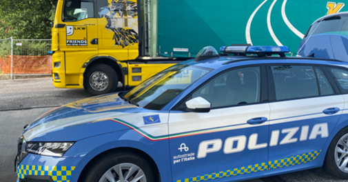 Italienisches Polizeiauto mit der Aufschrift Polizia steht vor einem LKW.