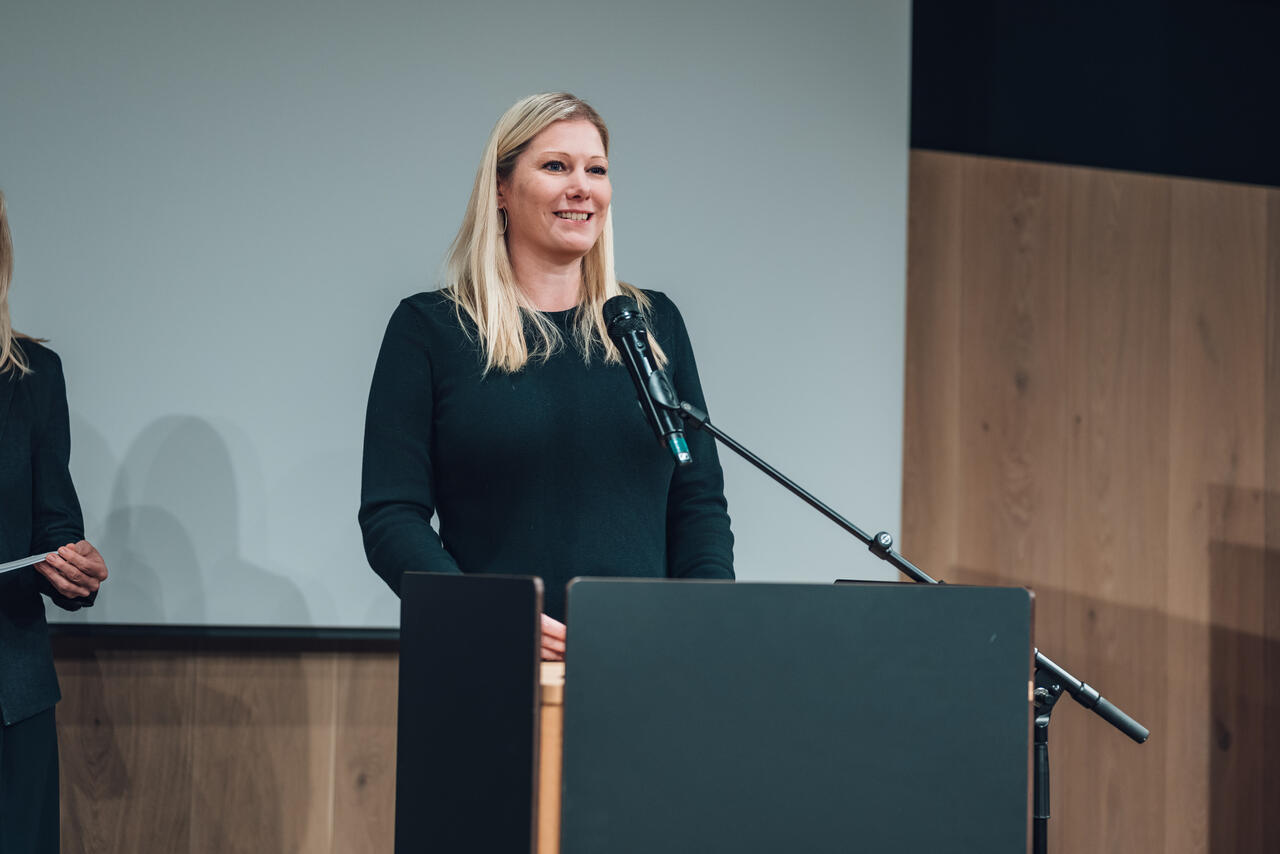 Melanie Graf spricht an einem Rednerpult.
