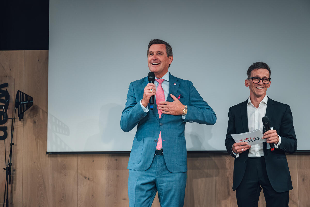 Bundesminister Peter Hanke spricht auf der Bühne, er und Moderator Stephanos Berger lachen.