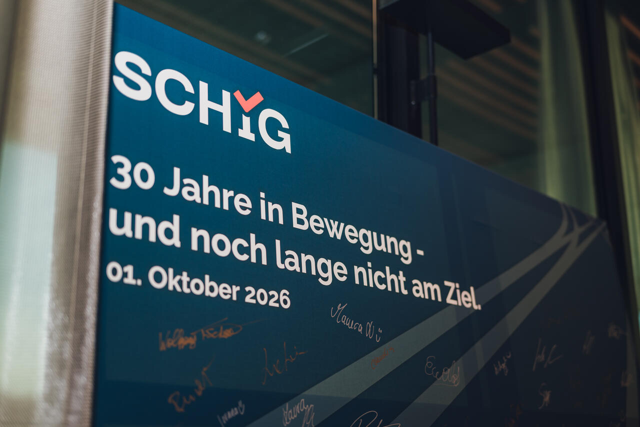Leinwand mit SCHIG Logo und Slogan: 30 Jahre in Bewegung - und noch lange nicht am Ziel. 01. Oktober 2026