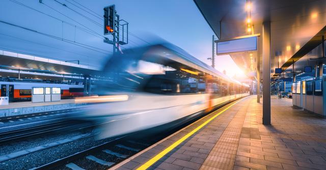 Zug fährt durch Bahnhof, sein Erscheinungsbild ist leicht verschwommen