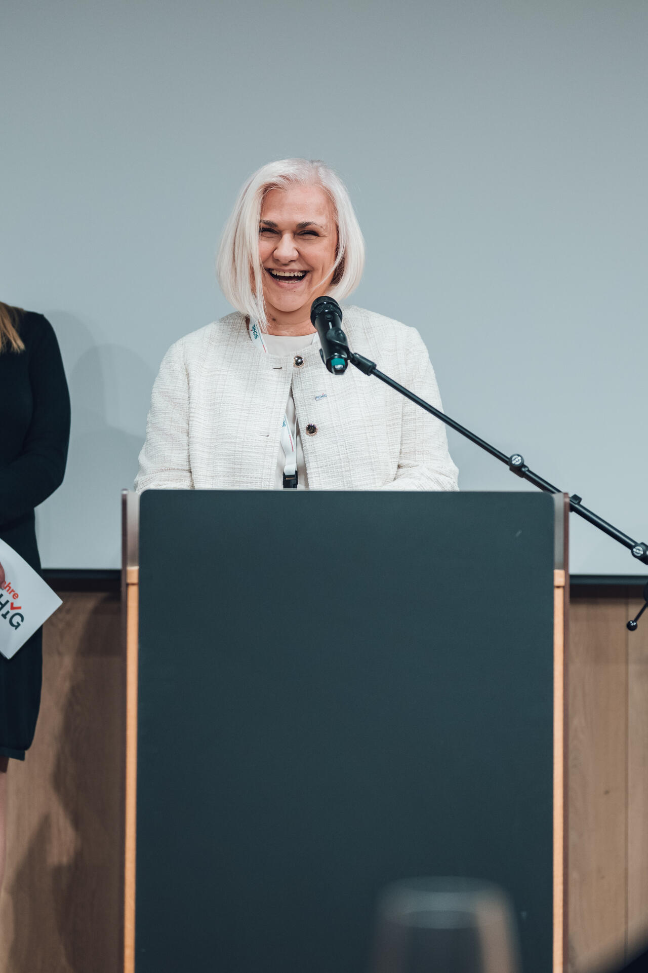 Ivanka Terzic steht an einem Sprecherpult und lächelt.