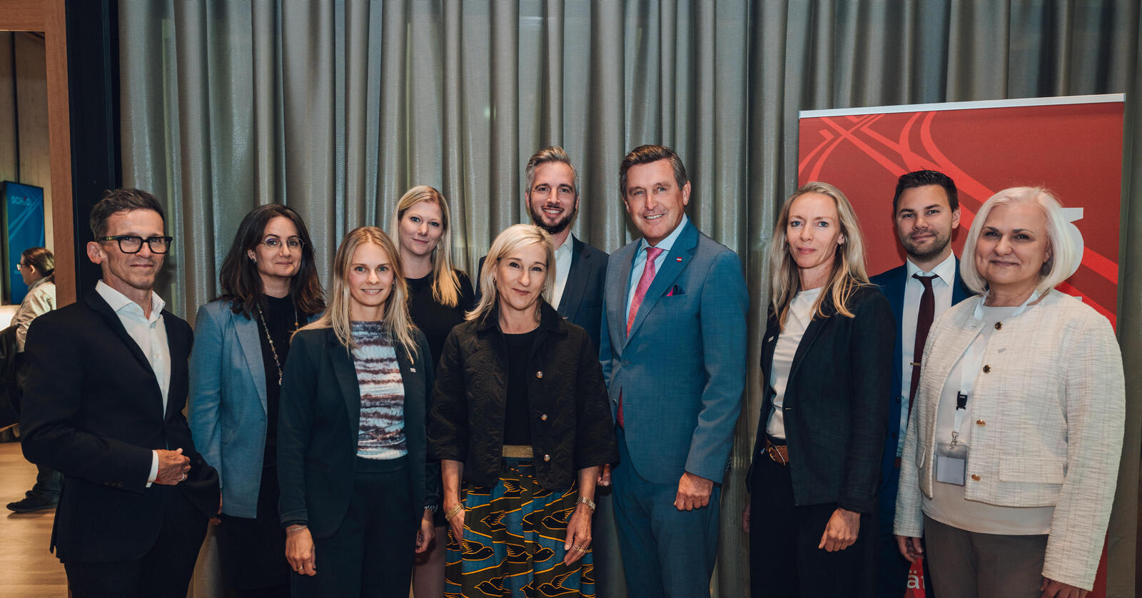 Eine Gruppe an Menschen steht in einem festlichen Raum, Bundesminister Peter Hanke in der Mitte.