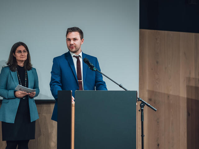 Michael Schmid spricht an einem Rednerpult.