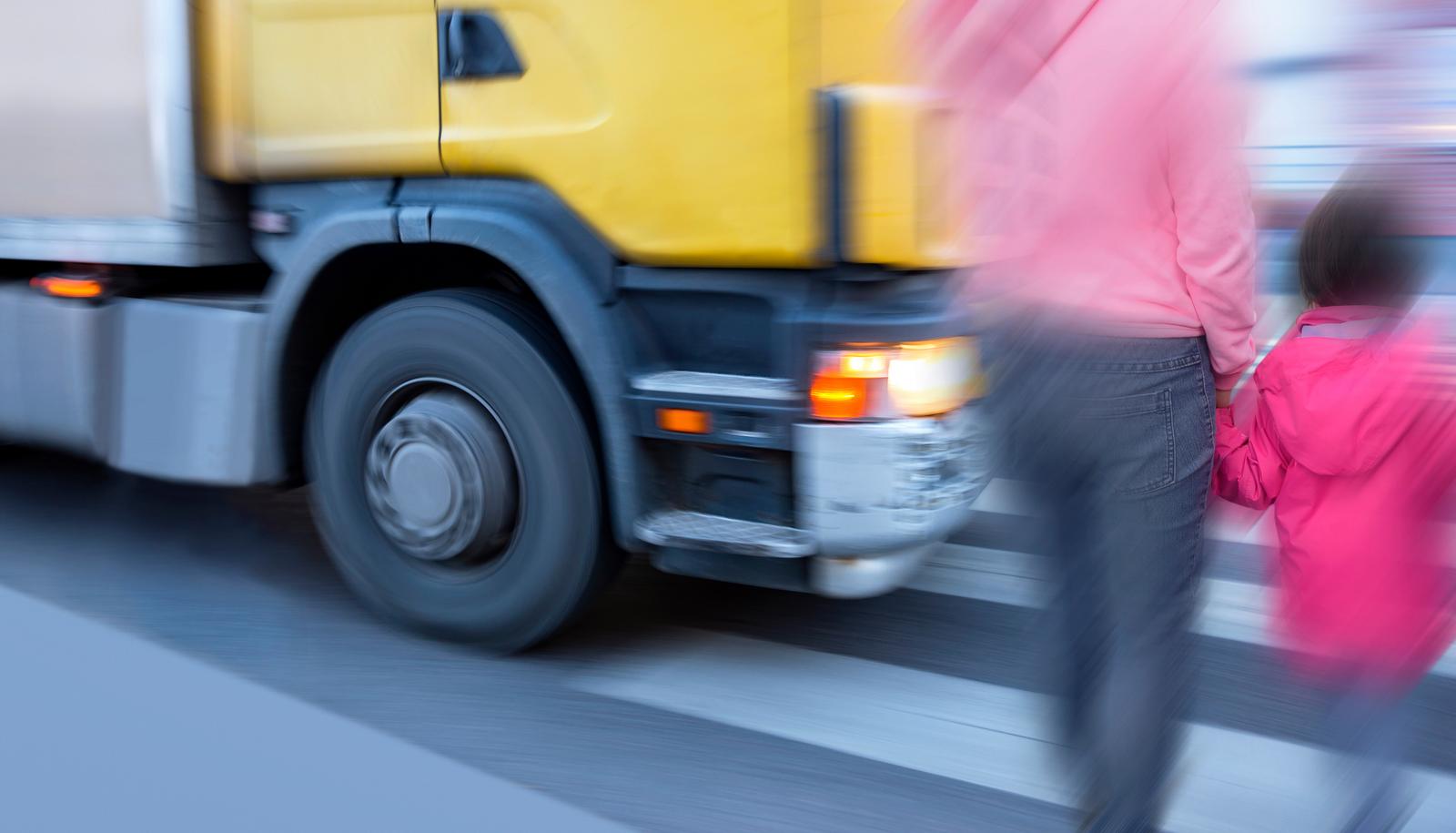 LKW fährt knapp an Mutter mit Kind